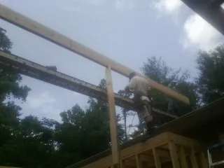 Carpenter setting a ridge beam over a new addition frame — Ice Dam Removal by Roofing Brothers in Dodge